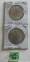 Front side of two French Indochina Piastre coins in holders, dated 1905 and 1908 with inscription and figure of Liberty.