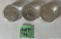 Three coins reverse showing canoe, Santa Claus, Star Trek designs with green LOT 11 note