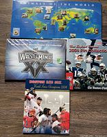 Four complete pin sets displayed on the floor including Animals of the World map, WrestleMania XX box, New England Patriots 2004 Red Sox pin collections.