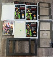 Collection of comic book supplies including resealable Ultra PRO golden size comic bags, comic book price guide, storage sleeves, and black display frames.