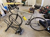 Side view of assembled Norco CRD bicycle with rear rack and cycling shoes on the floor.