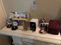 Photo showing seven Calvin Klein analogue watches with colorful leather straps, one Timex digital watch in box, various costume jewelry in cases, and fabric box for storage.