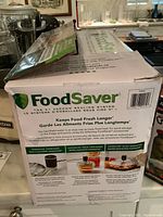 Photo of original FoodSaver box showing branding, slogan, and accessory usage instructions.