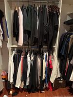 Two racks of ladies clothing with various jackets, sweaters, tops, and blouses hung on hangers.