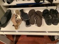 Collection of various ladies shoes including flats, sandals, and casual shoes on shelf