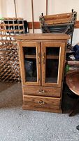 Front view of solid wood stereo stand cabinet with glass doors and two drawers.