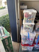 Four clear plastic bins stacked, each containing assorted Beanie Babies