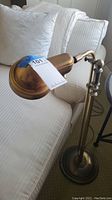 Full view showing adjustable arm and dome-shaped brass shade.