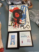 Photo of three framed prints on the floor, the largest is a colorful abstract Miró print from Galerie Maeght.