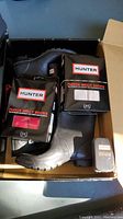 Photo showing black Hunter rain boots in box along with two packets of fleece Welly socks and a small box of instant body wax.