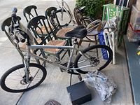 Sedona DX silver mountain bike leaning near chairs with packed items nearby.