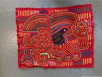 Photo of quilted embroidered textile art depicting an abstract bird with a figure next to it on red fabric