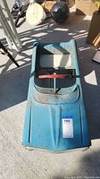 Top-down view showing full body, seat area, steering wheel, and surface condition.