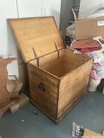 Open top view showing interior wooden panels and metal support brackets for lid.