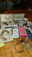 Overview of costume jewelry including boxed sets, bracelets, earrings and brooches displayed on table
