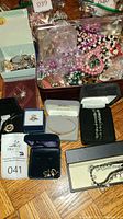 Full view of multiple pieces of costume jewelry including beaded necklaces, bracelets, earrings and boxes