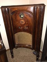 Full view of Philco Baby Grand console radio showing wooden cabinet and fabric speaker grille.