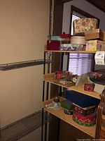 Metal shelving with three wire shelves loaded with various decorative boxes and some other items.