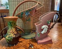 Three Roseville USA pottery pieces displayed on table showing their size and condition including broken handle and chips.