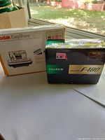 Kodak EasyShare box and Fujifilm FinePix F480 box placed on a windowsill showing original packaging for the cameras.