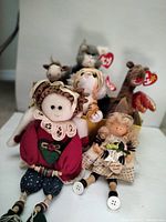Photo of five Ty Beanie Babies plush dolls with visible red heart tags, including a giraffe, tiger, gray animal, cat, and a doll holding a 'Get Well Soon' sign.