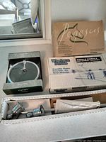 Western Pride kitchen faucet in box alongside Pegasus shower kit box and Gatsby towel ring in packaging