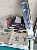 Photo showing the Western Pride single handle kitchen faucet with hand spray in original box, Peerless tub/shower faucet kit box, and Moen towel bar in packaging.