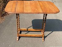 Front view of antique solid oak barley twist drop leaf table with drop leaves extended.