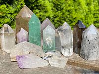 Full set of 14 faceted crystal points displayed on wooden surface