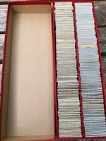 Long view of three red sleeved boxes showing large quantity of white sleeved coins organized inside.