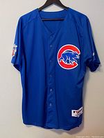 Front view of blue Chicago Cubs baseball jersey with button-up front and large team logo on chest.