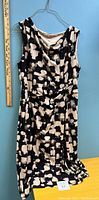 Full view of the sleeveless dress hanging showing front design and length
