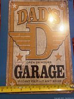 Photo showing the full front of the rectangular metal sign with measurement ruler for scale.