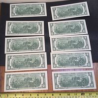 Ten consecutive $2 bills laid out in two columns, showing the back side with the Declaration of Independence scene.