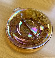 Divided section carnival glass plate with iridescent finish and embossed patterns.