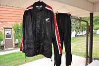 Front view of the Honda rain jacket and pants hanging side by side showing design and logos on the jacket.