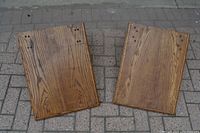 Two solid oak shelves laying flat showing the wood grain and drilled mounting holes.