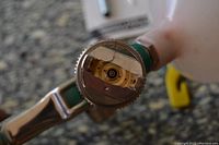 Close-up of spray gun nozzle showing detailed metal construction and adjustment mechanism