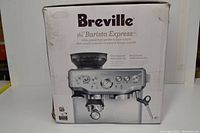 Front of box labeled “Breville the Barista Express” showing machine graphic