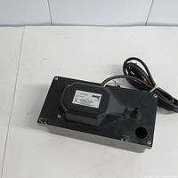Top angle view of black furnace drain water pump showing general shape and attached power cord.