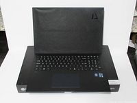 Opened laptop on top of its box showing keyboard and screen cover