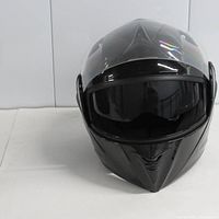 Front view of glossy black full-face motorcycle helmet with clear visor and inner sun shield lowered