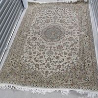Full view of the Persian rug laid out showing the floral pattern and central medallion