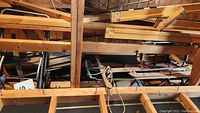 Wooden sleds and a handcart stored in garage rafters, showing overall lot in storage position.