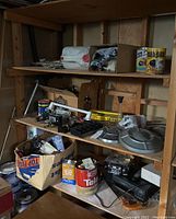 Shelf with assorted auto supplies, hardware boxes, hand tools, automotive cans including a TEL can, and various other miscellaneous items.