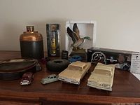 Photo of entire lot showing vintage model cars, ashtrays, pipes, humidor, and advertising miniatures.