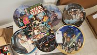 Top-down view of Star Wars decorative plates and 4 Marvel Star Wars comics showing the lot contents