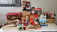 Lot overview showing assorted vintage Christmas decorations, ornaments, wood nativity set, avocado boxes, and miniature light sets