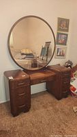 Full view of vanity showing two drawer pedestals, center knee space, and attached round mirror