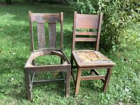 Two solid oak antique chairs outdoors on grass, showing overall condition and seat damage.